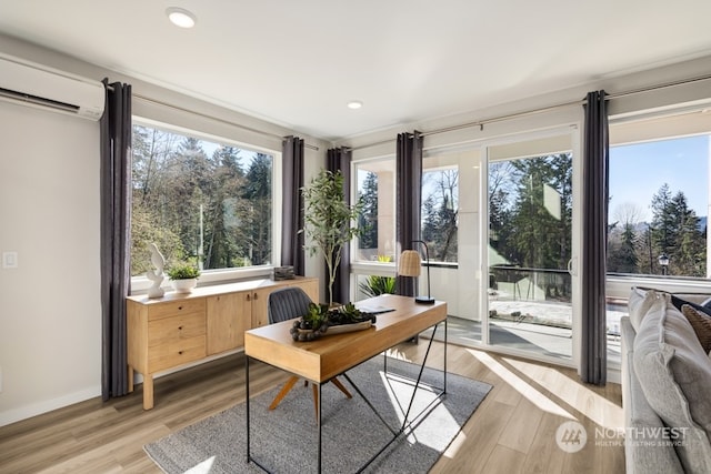 home office featuring light wood-type flooring and an AC wall unit