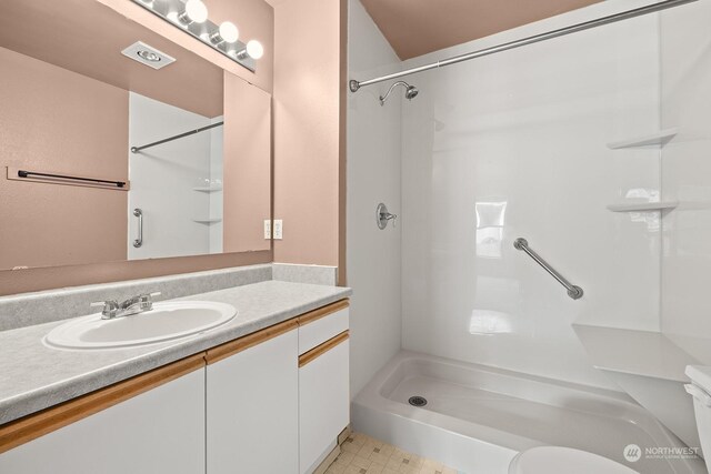 bathroom featuring vanity, walk in shower, toilet, and tile patterned flooring