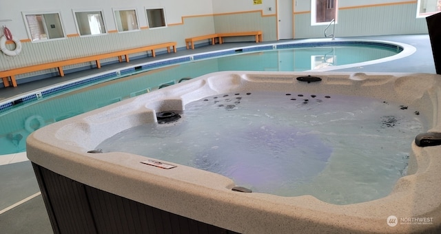 view of swimming pool with a hot tub