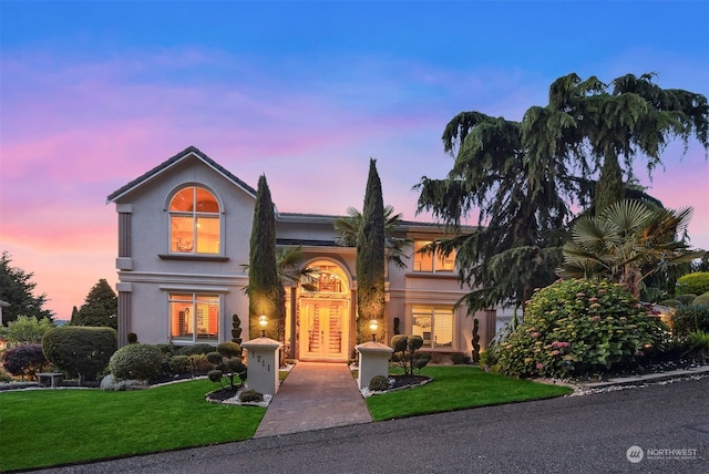 view of front facade with a yard and french doors