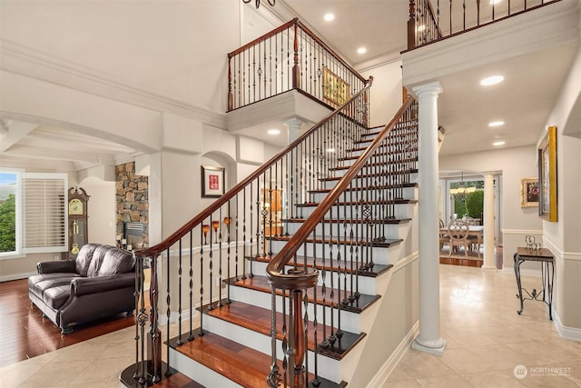 stairway featuring plenty of natural light, ornamental molding, and decorative columns