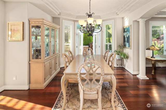 dining area with dark hardwood / wood-style flooring, a healthy amount of sunlight, an inviting chandelier, and decorative columns