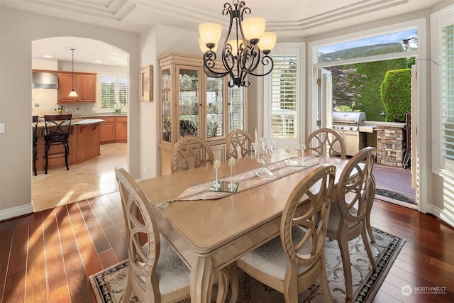 dining area featuring light hardwood / wood-style floors, an inviting chandelier, and ornamental molding