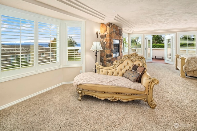 sitting room featuring a stone fireplace, carpet, and a textured ceiling