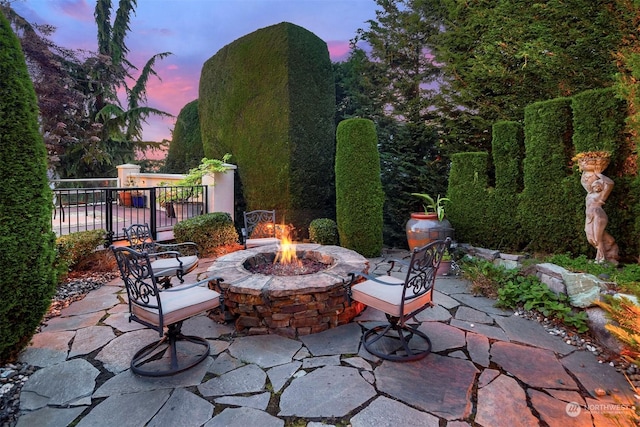 patio terrace at dusk featuring an outdoor fire pit