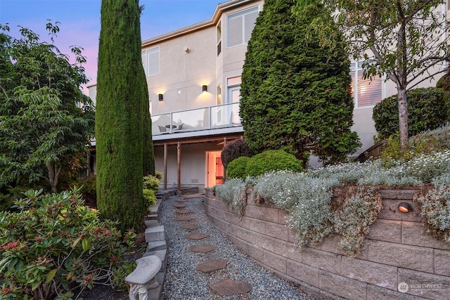 property exterior at dusk with a balcony