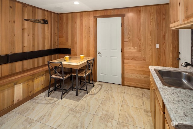 dining area featuring wood walls and sink