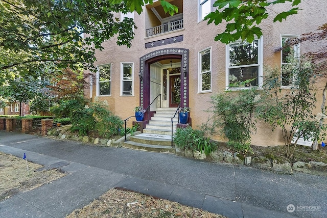 view of exterior entry featuring a balcony