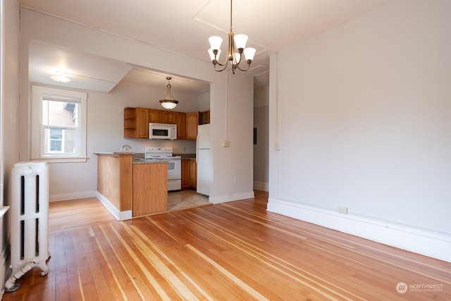 unfurnished living room with a notable chandelier, radiator, and light hardwood / wood-style flooring