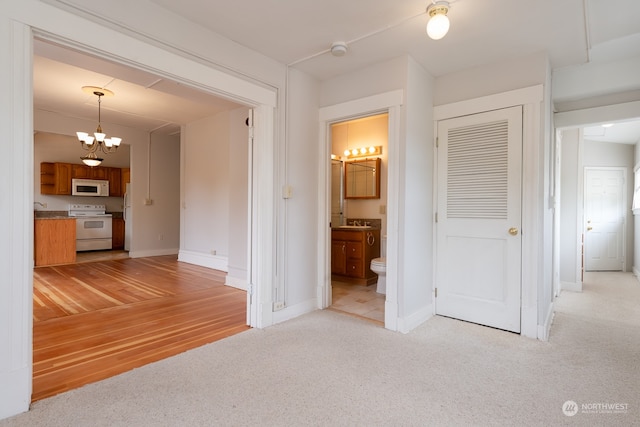 unfurnished living room featuring an inviting chandelier and light carpet