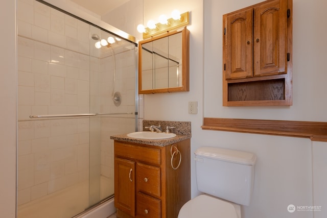 bathroom with an enclosed shower, large vanity, and toilet