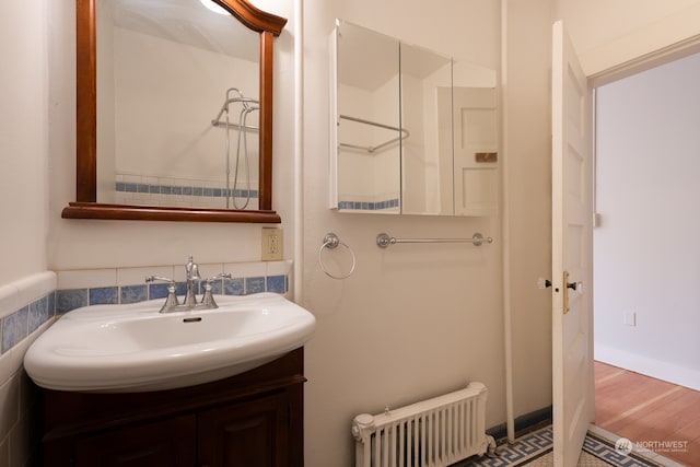 bathroom with wood-type flooring, radiator heating unit, and vanity