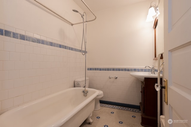 full bathroom featuring tile walls, toilet, tile flooring, tiled shower / bath, and vanity