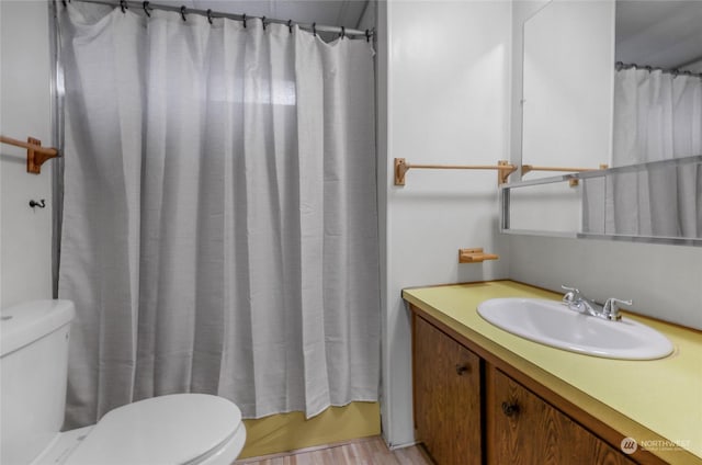 full bathroom with toilet, hardwood / wood-style floors, shower / bath combo, and vanity