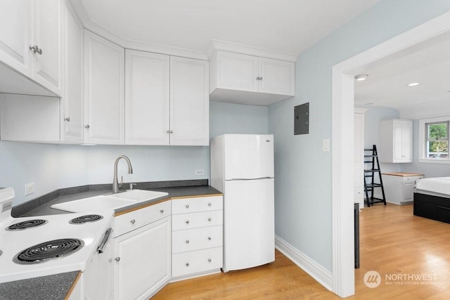 kitchen with white refrigerator, white cabinetry, sink, and light wood-type flooring