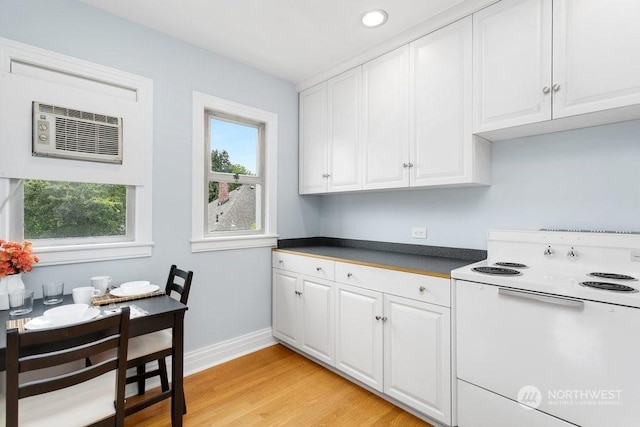 kitchen featuring light wood-type flooring, white cabinets, and white range with electric cooktop