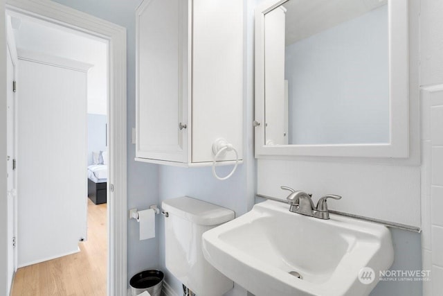 bathroom with hardwood / wood-style flooring, sink, and toilet