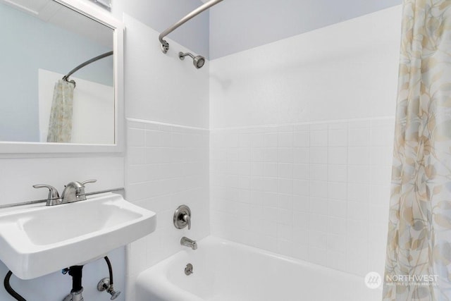 bathroom with shower / bathtub combination with curtain and sink