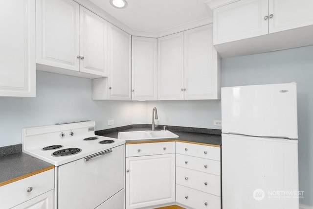 kitchen featuring white cabinetry, sink, and white appliances