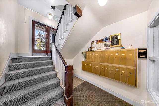 stairs featuring vaulted ceiling, carpet, and a mail area