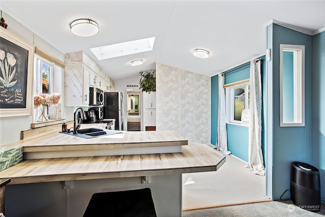dining room featuring lofted ceiling with skylight