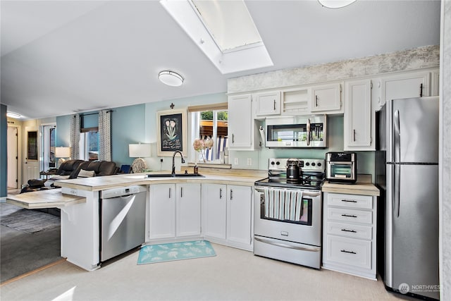 kitchen with a healthy amount of sunlight, stainless steel appliances, light countertops, and a sink