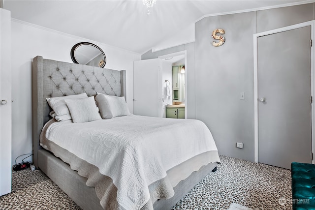 bedroom featuring lofted ceiling, ornamental molding, and ensuite bathroom