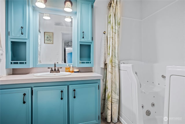 full bathroom featuring a tub with jets and vanity
