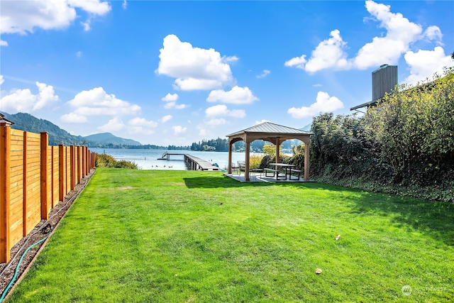 view of yard with fence, a water and mountain view, and a gazebo