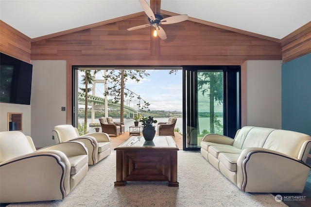 living room featuring ceiling fan, wood walls, and lofted ceiling