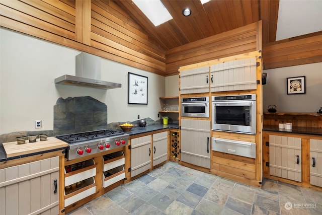 kitchen with vaulted ceiling with skylight, appliances with stainless steel finishes, wood ceiling, and ventilation hood