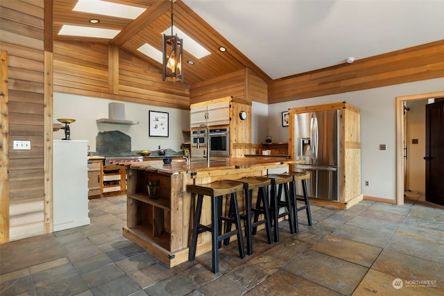 kitchen with wooden counters, a skylight, wood ceiling, stainless steel appliances, and high vaulted ceiling