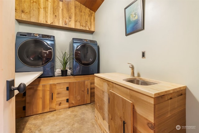 laundry area featuring washing machine and clothes dryer, sink, and cabinets