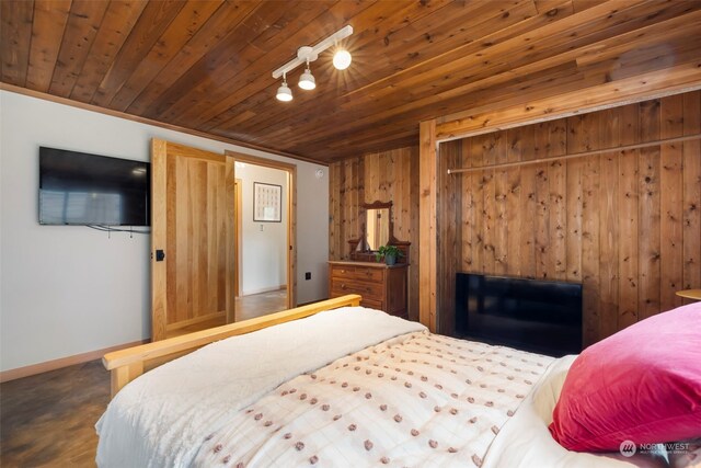 bedroom featuring wood walls, crown molding, wood ceiling, and track lighting