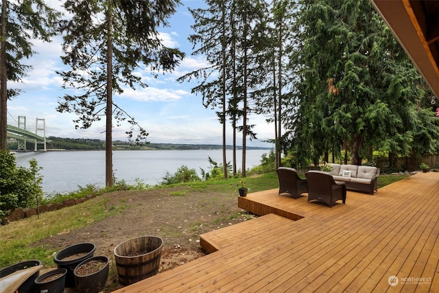 wooden deck with outdoor lounge area and a water view