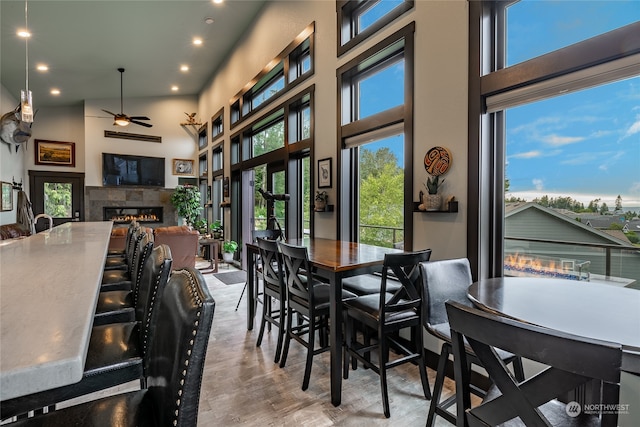 dining area featuring a high ceiling, ceiling fan, and a wealth of natural light