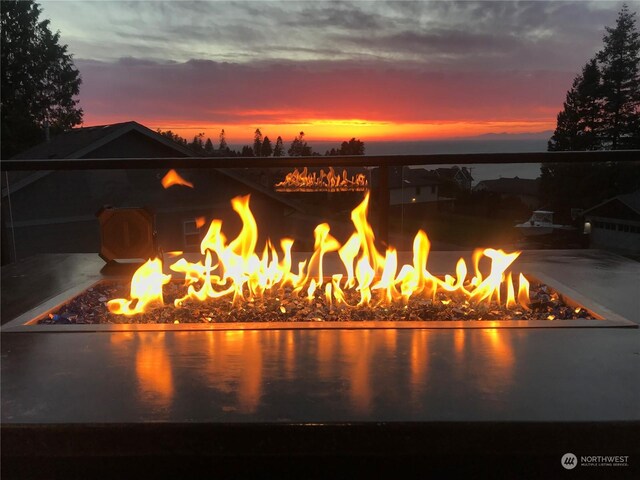 exterior space featuring a water view and an outdoor fire pit