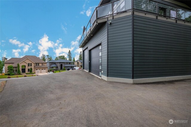 view of property exterior with a garage and a balcony