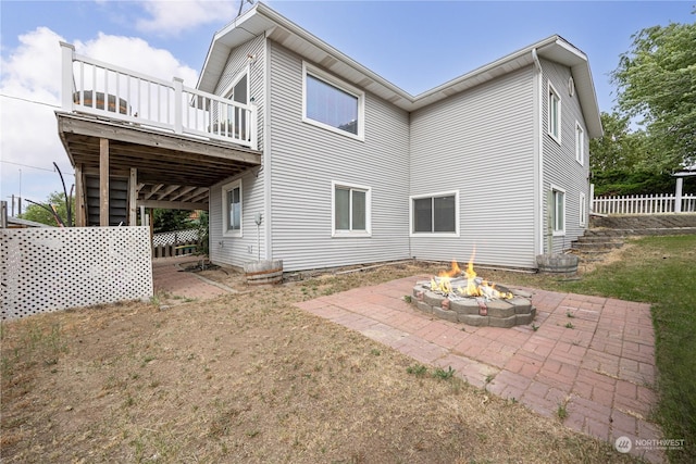 rear view of house with a patio area, a deck, and an outdoor fire pit