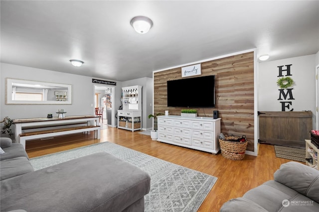 living room featuring hardwood / wood-style flooring and wooden walls