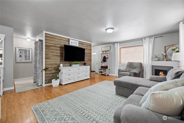 living room with wooden walls, a fireplace, and wood-type flooring