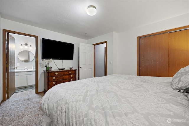 carpeted bedroom with connected bathroom and a closet