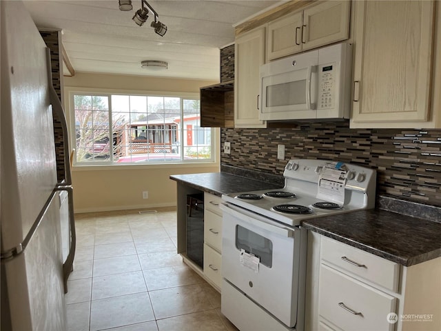 kitchen featuring tasteful backsplash, light tile patterned floors, and white appliances