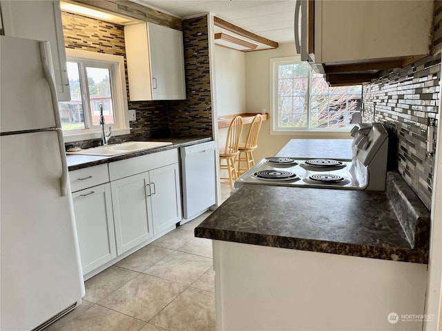 kitchen with white cabinetry, sink, backsplash, light tile patterned floors, and white appliances