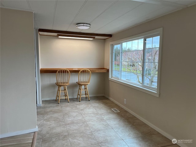 unfurnished dining area with bar area