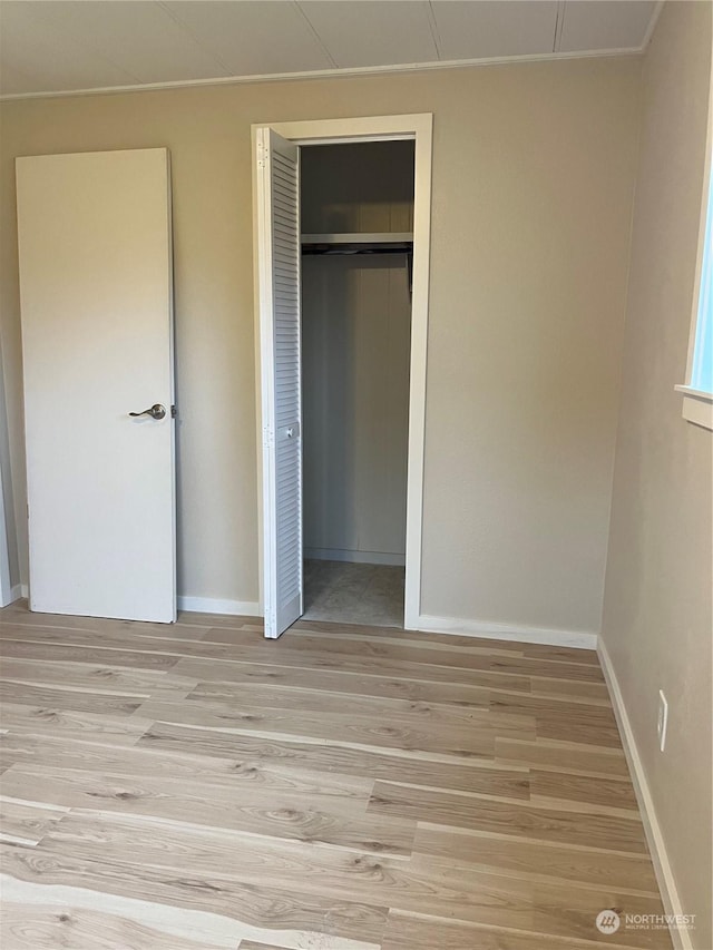 unfurnished bedroom with light hardwood / wood-style floors and a closet