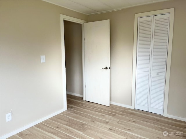 unfurnished bedroom featuring light hardwood / wood-style floors and a closet