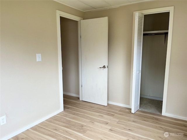 unfurnished bedroom featuring light wood-type flooring and a closet