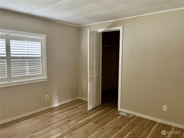 unfurnished bedroom with light hardwood / wood-style floors and a closet