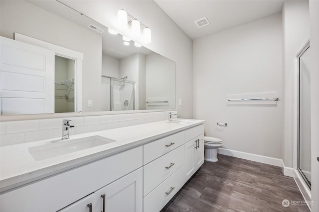 bathroom with vanity, hardwood / wood-style flooring, toilet, and a shower with shower door